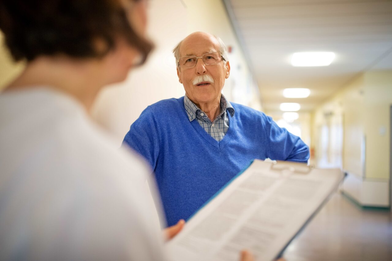 Un patient discute avec un membre de l'équipe médiale suite à une Récupération Rapide Après Chirurgie (RRAC)